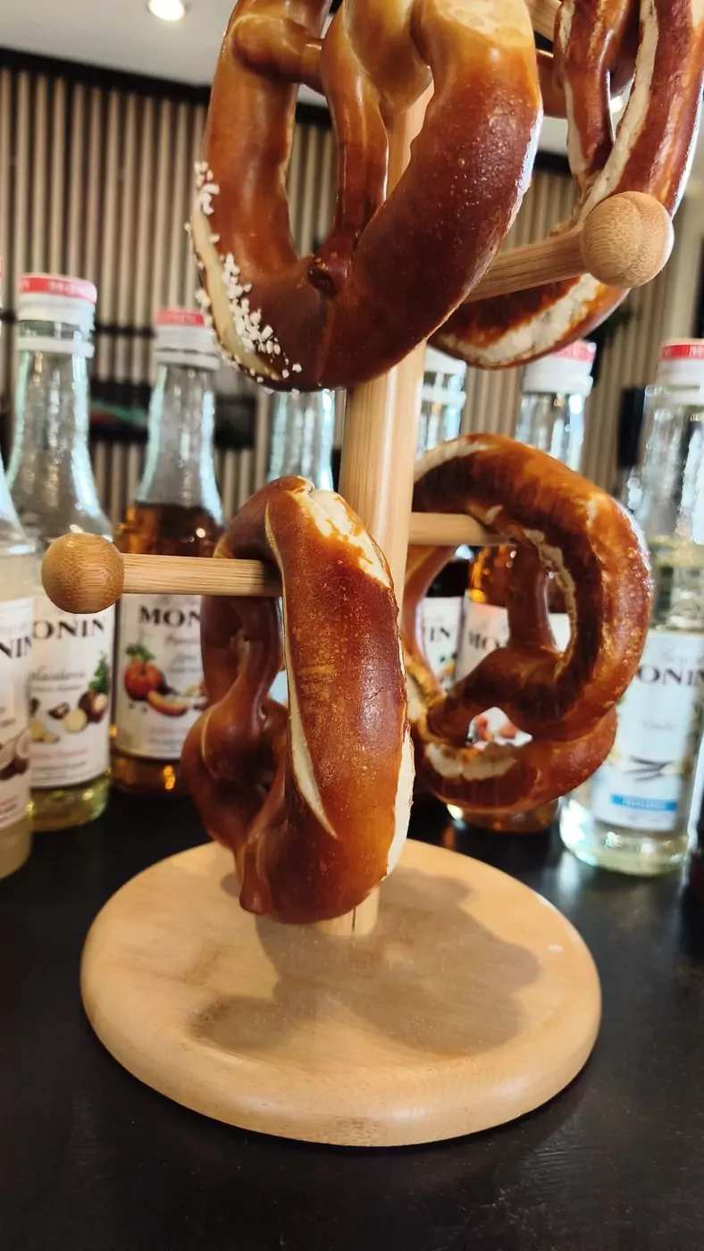 Frische Laugenbrezeln an der Café-Theke mit Monin-Sirupen im Hintergrund