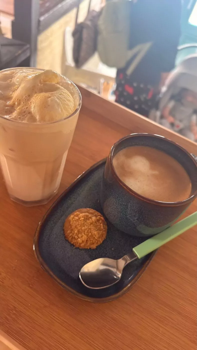 Eiskaffee und Cappuccino mit Keks auf Holzbrett
