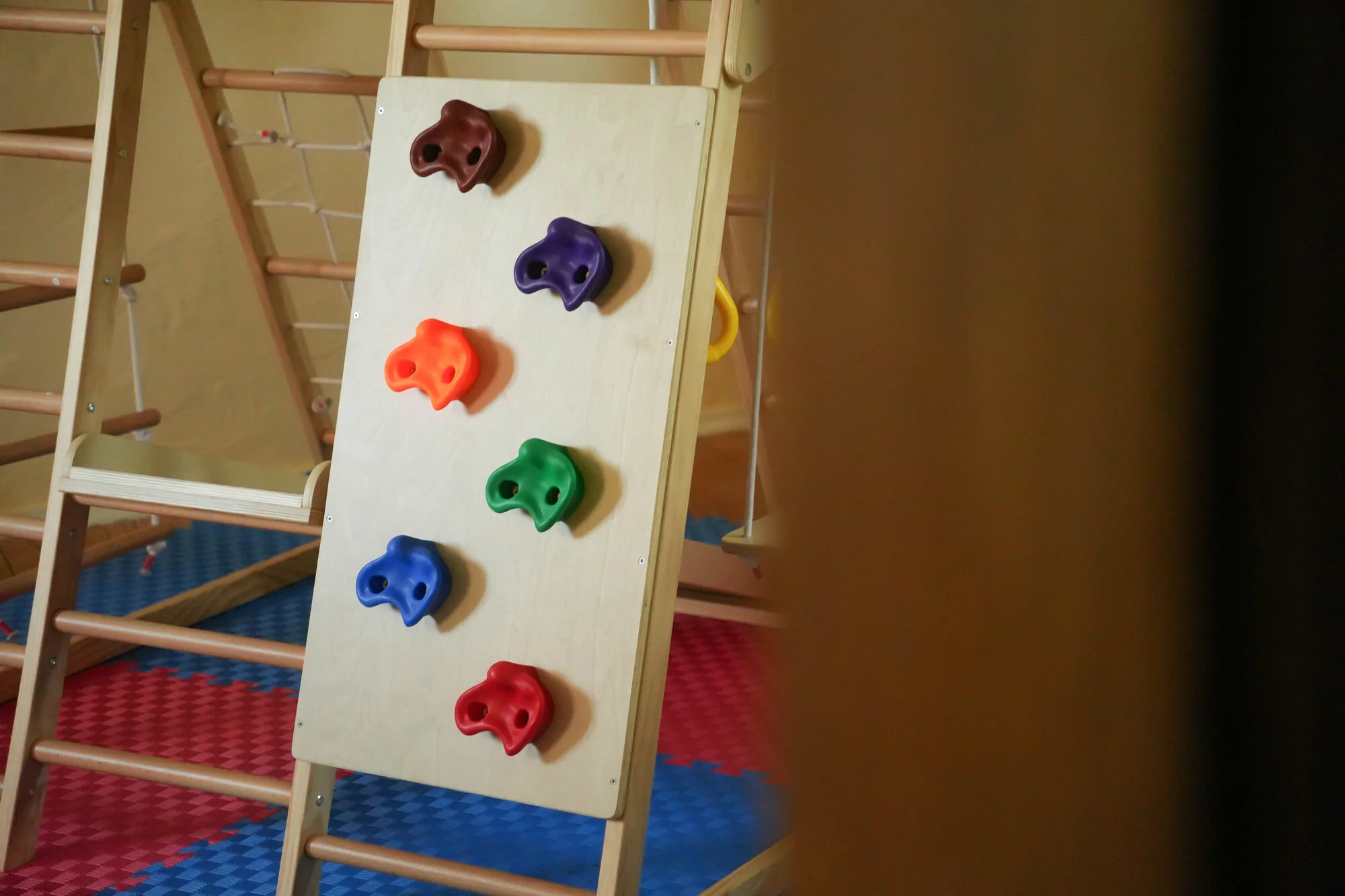 Bunte Klettersteine an der Spielraum-Kletterwand