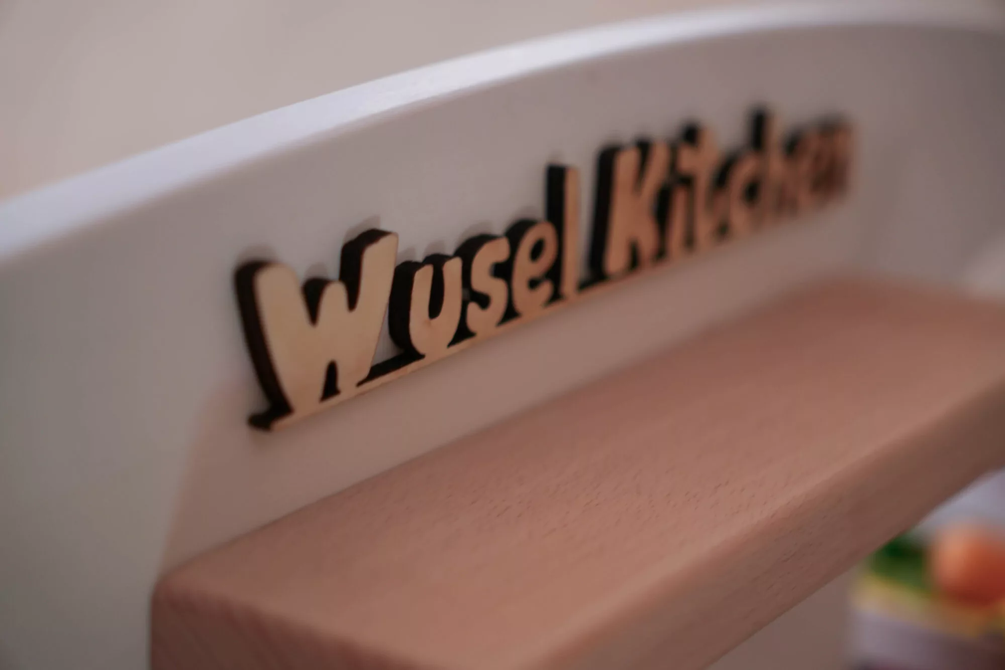 WuselKitchen-Holzschriftzug an der Kinder-Spielküche
