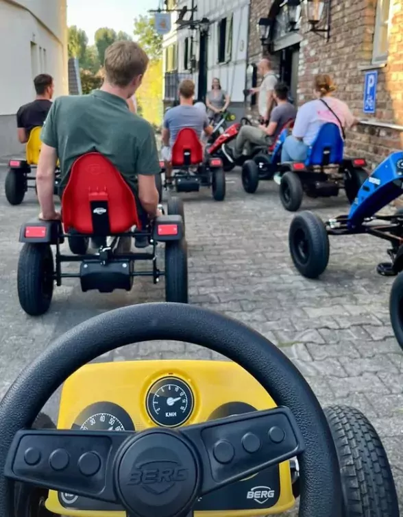 POV-Aufnahme aus einem Kettcar mit fahrenden Kindern durch die Gasse