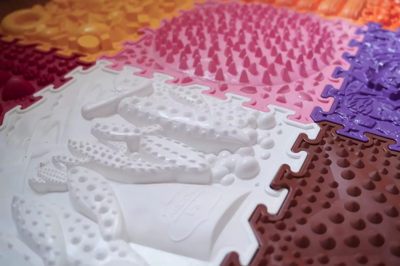 Bunte Puzzleteile einer Sensory-Matte im Bewegungsraum