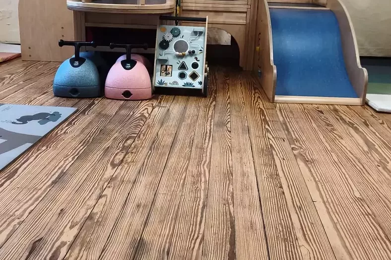 Holz-Klettergerüst mit Rutsche im Indoor-Spielraum